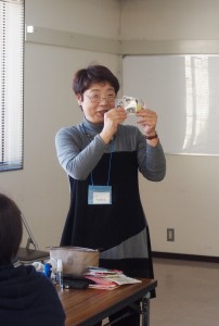 家族の写真の裏に連絡先を書いたものをパウチして携帯している小泉さん